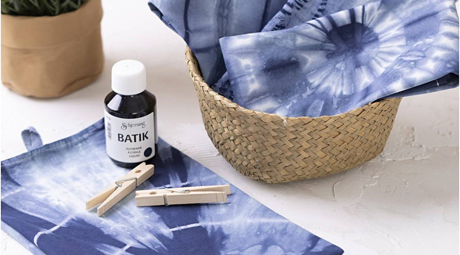 Blåt tie-dye-farvet stof med batikfarve og træklemmer